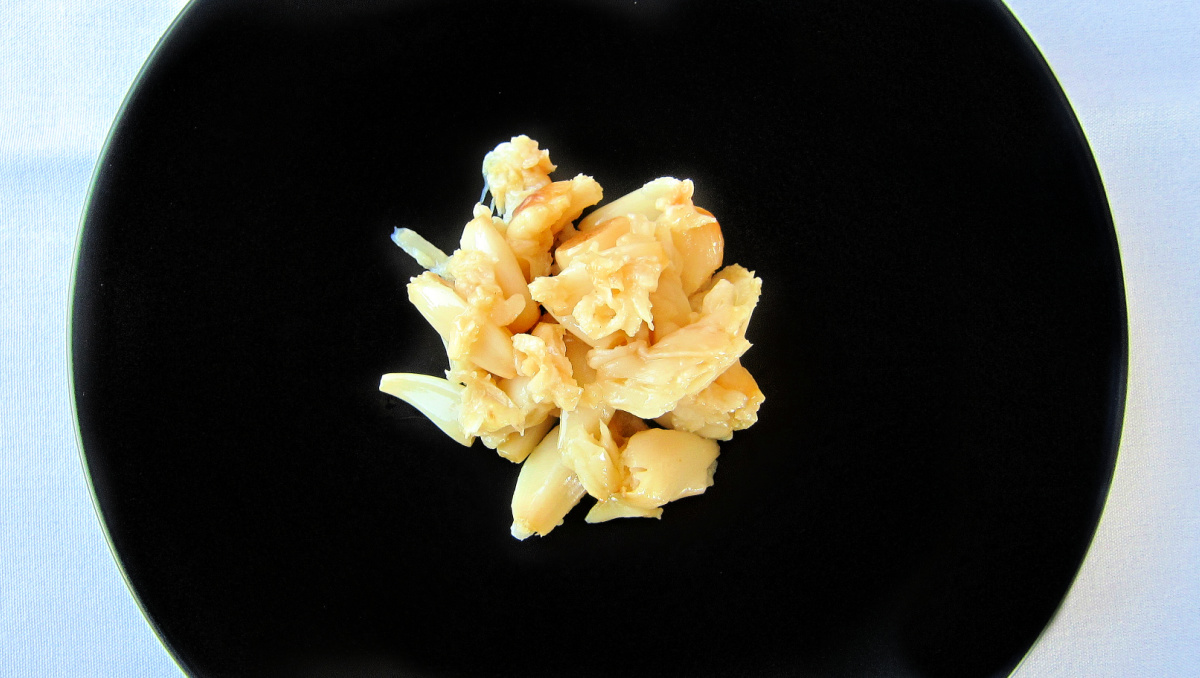 Pile of roasted garlic on a black plate