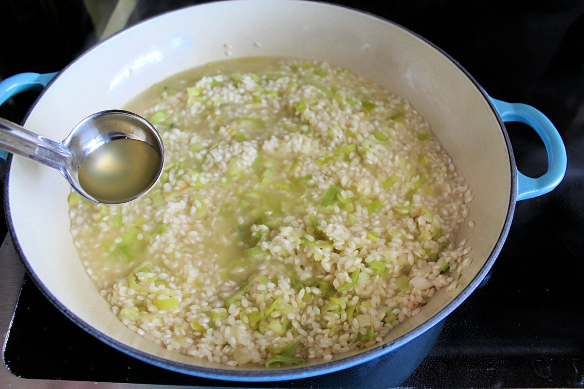 lemon risotto in skillet with stock being added