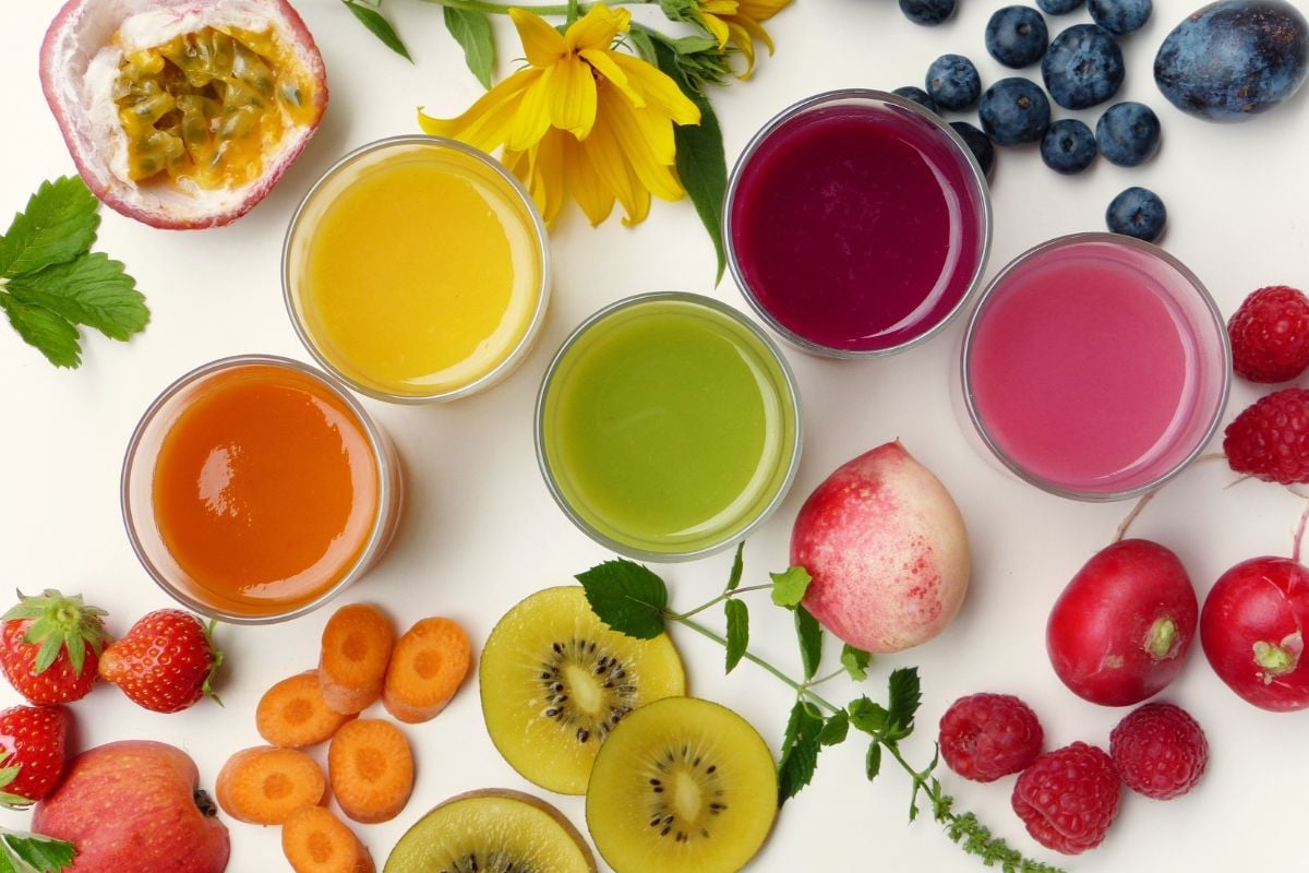 smoothies and fresh fruit on a white background
