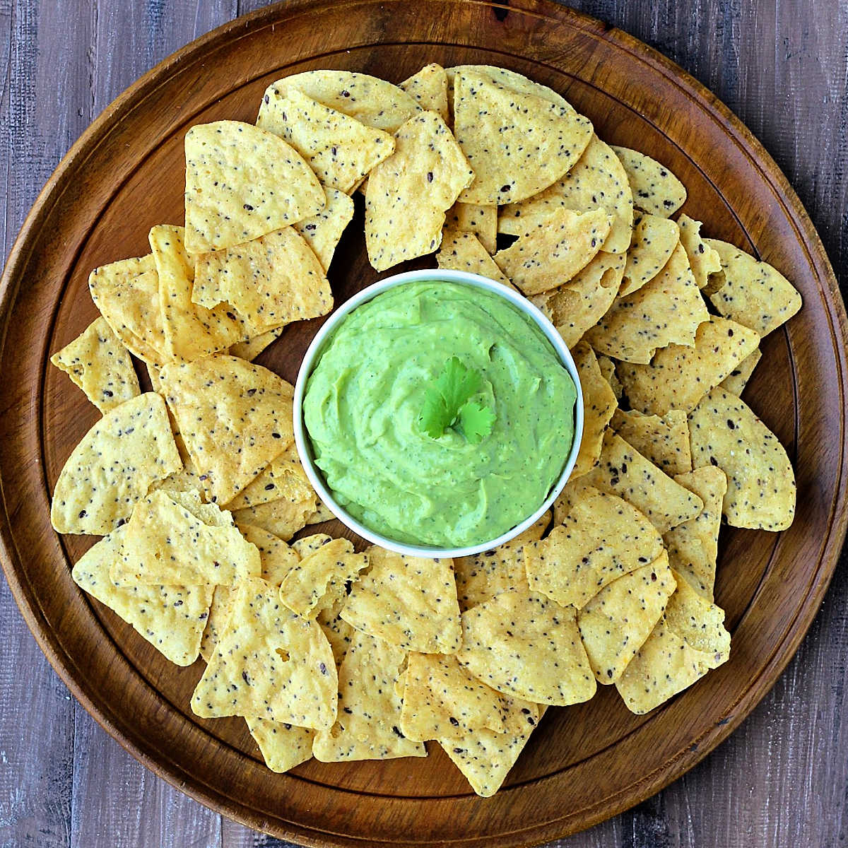 Avocado Yogurt Dip in a bowl surrounded by tortilla chips.