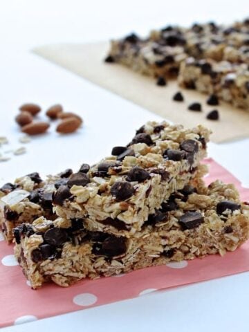Two granola chocolate cherry granola bars on a pink polka dot paper bag
