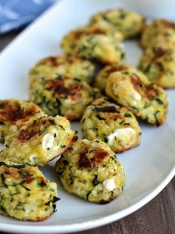 Zucchini tots on a white plate.
