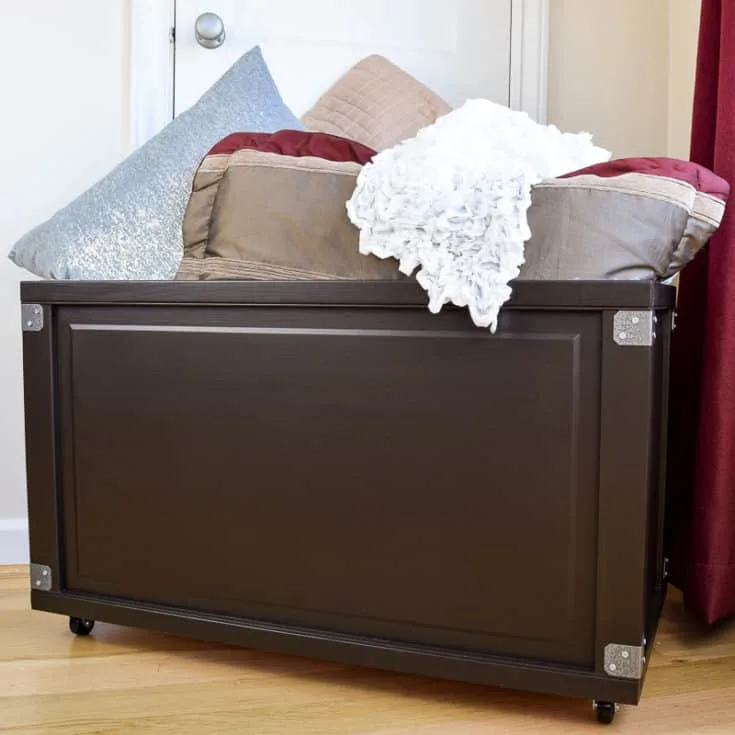 blanket storage bin filled with pillows and blankets