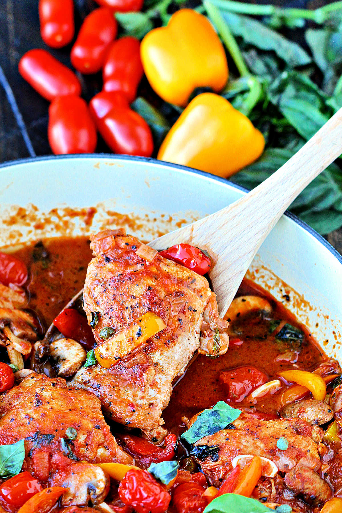 Spoonful of Quick and Easy Chicken Cacciatore being taken out of blue pan.