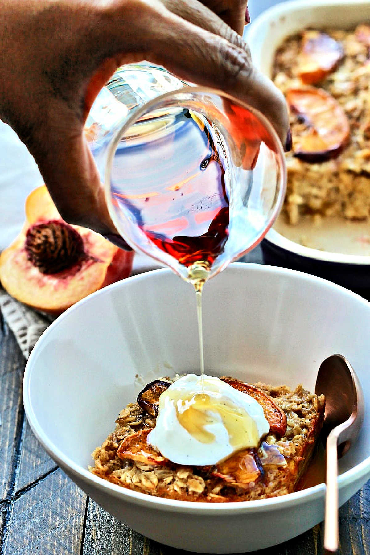 Maple syrup being poured onto Peach Baked Oatmeal.