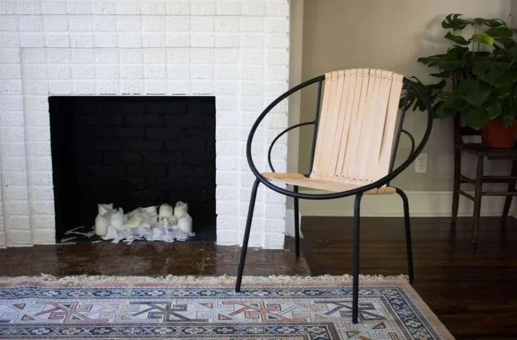 DIY leather chair with metal frame next to white fireplace