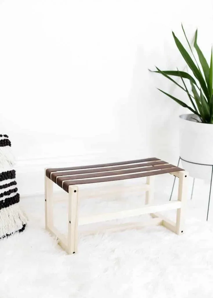 DIY leather footstool with white frame and brown leather on a white rug