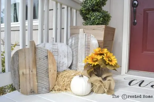wooden pumpkins made from pallets on white porch