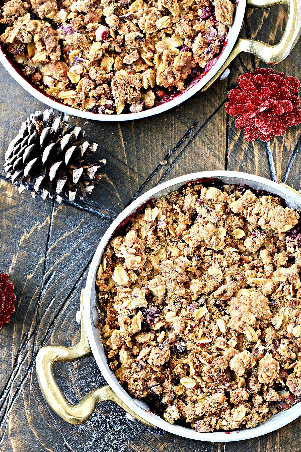 Overhead of two berry crisp in individual metal serving dishes