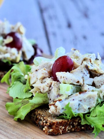 Chicken salad with grapes and almonds on a slice of multigrain bread.