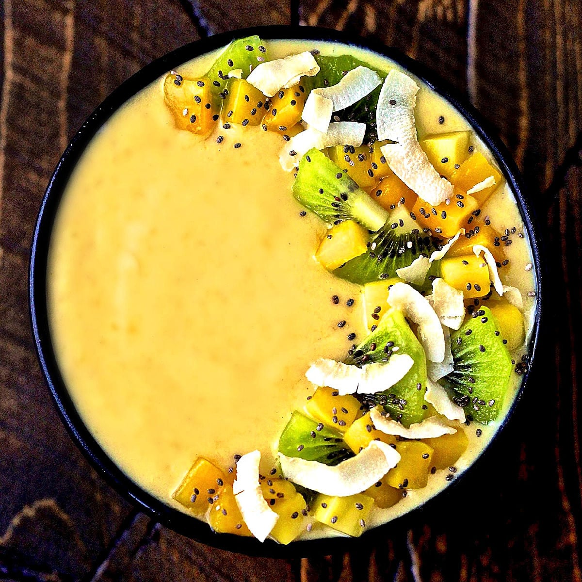 Tropical smoothie bowl in a black bowl.
