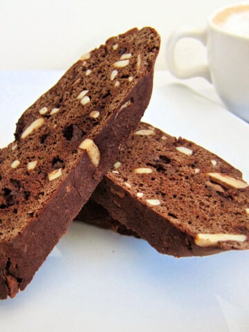 Two pieces of chocolate biscotti on a white plate.