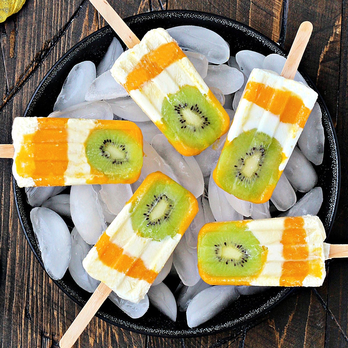 Kiwi Mango Popsicles on bowl of ice.