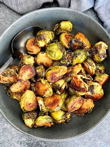 Miso roasted Brussels sprouts in a gray bowl.