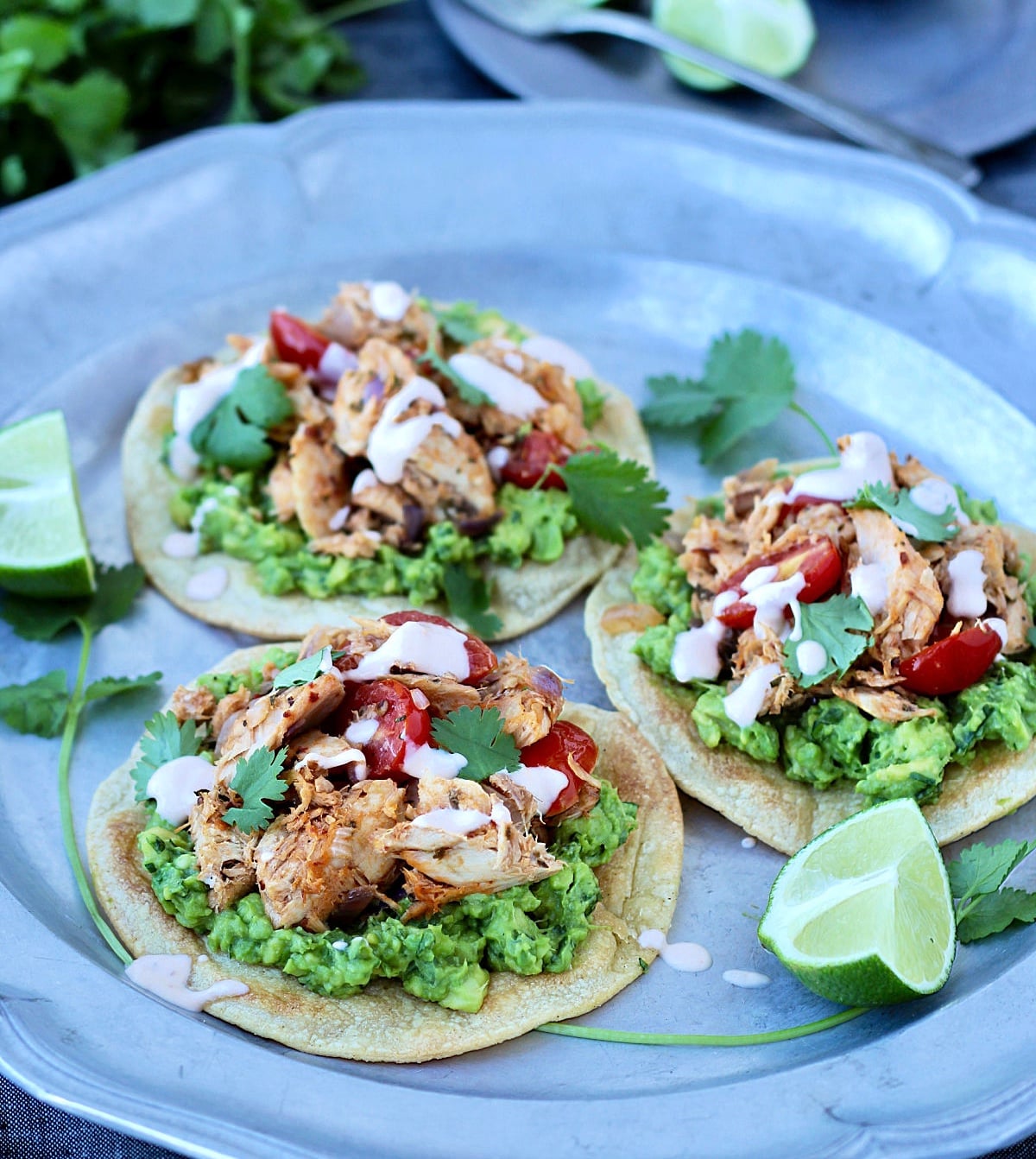 Three tuna tostadas on a silver plate.