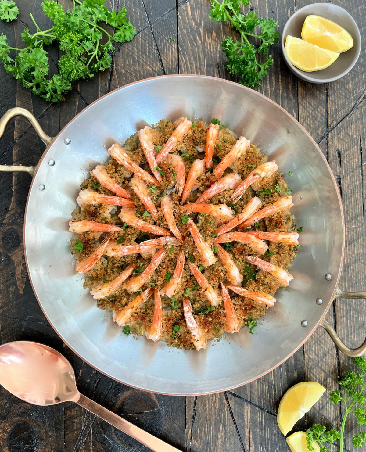 Overhead of shrimp oreganata arranged in a copper pan