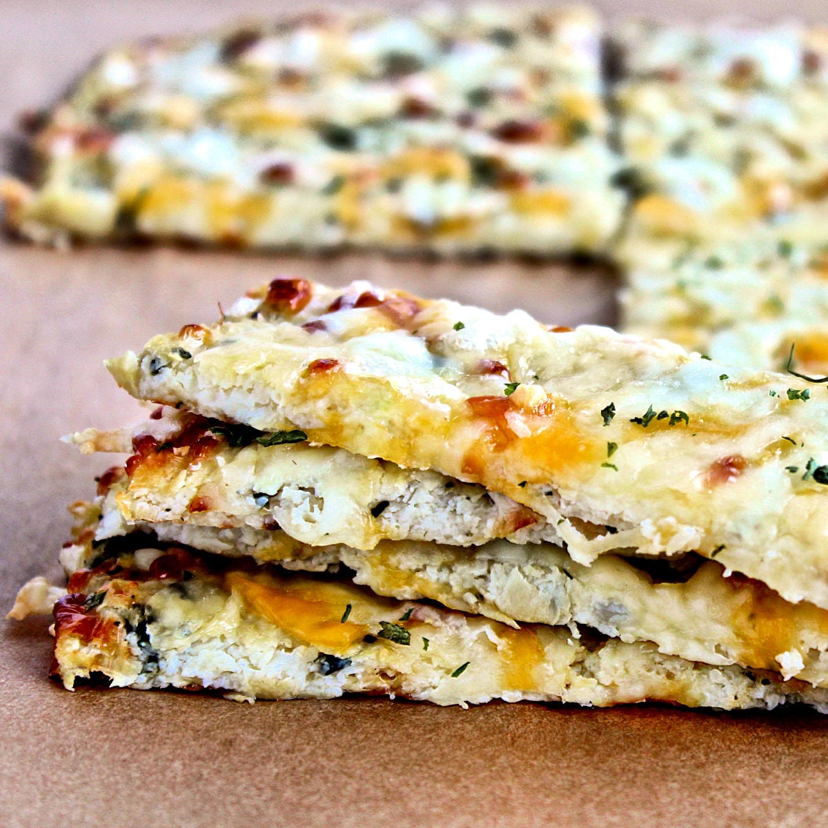 Cheesy cauliflower bread on parchment paper.