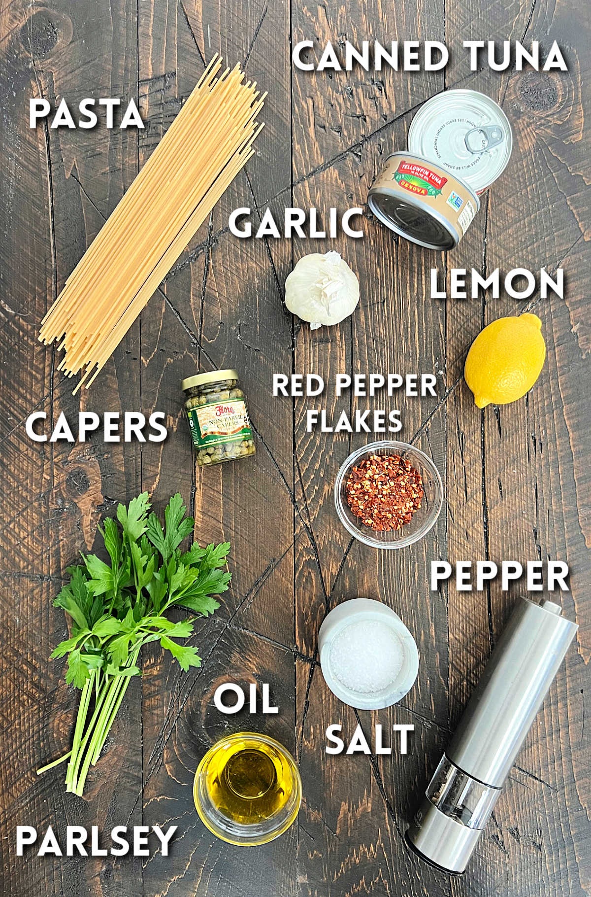 Ingredients for tuna pasta on a wooden board. 