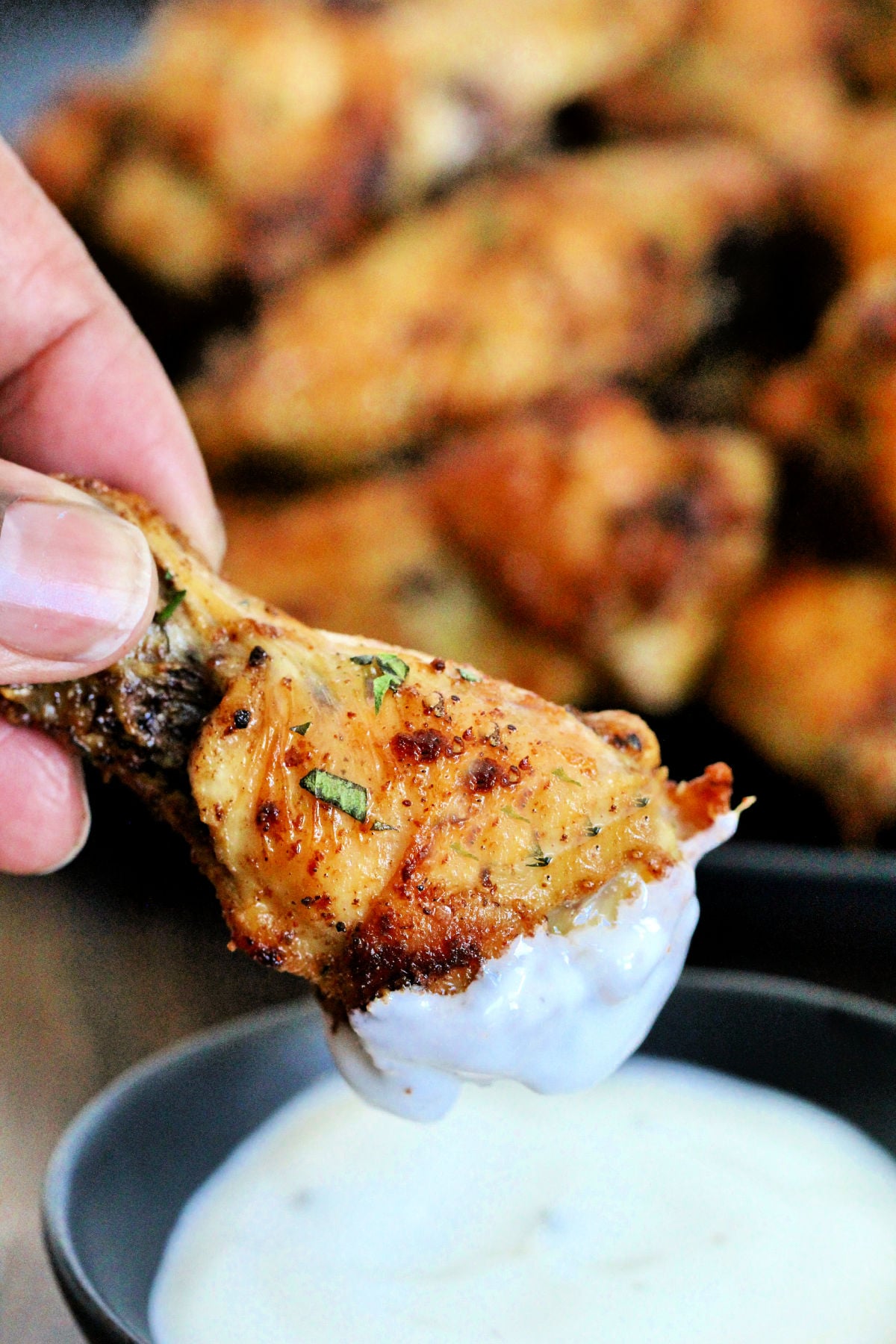 Dipping an air fryer chicken wing in ranch sauce
