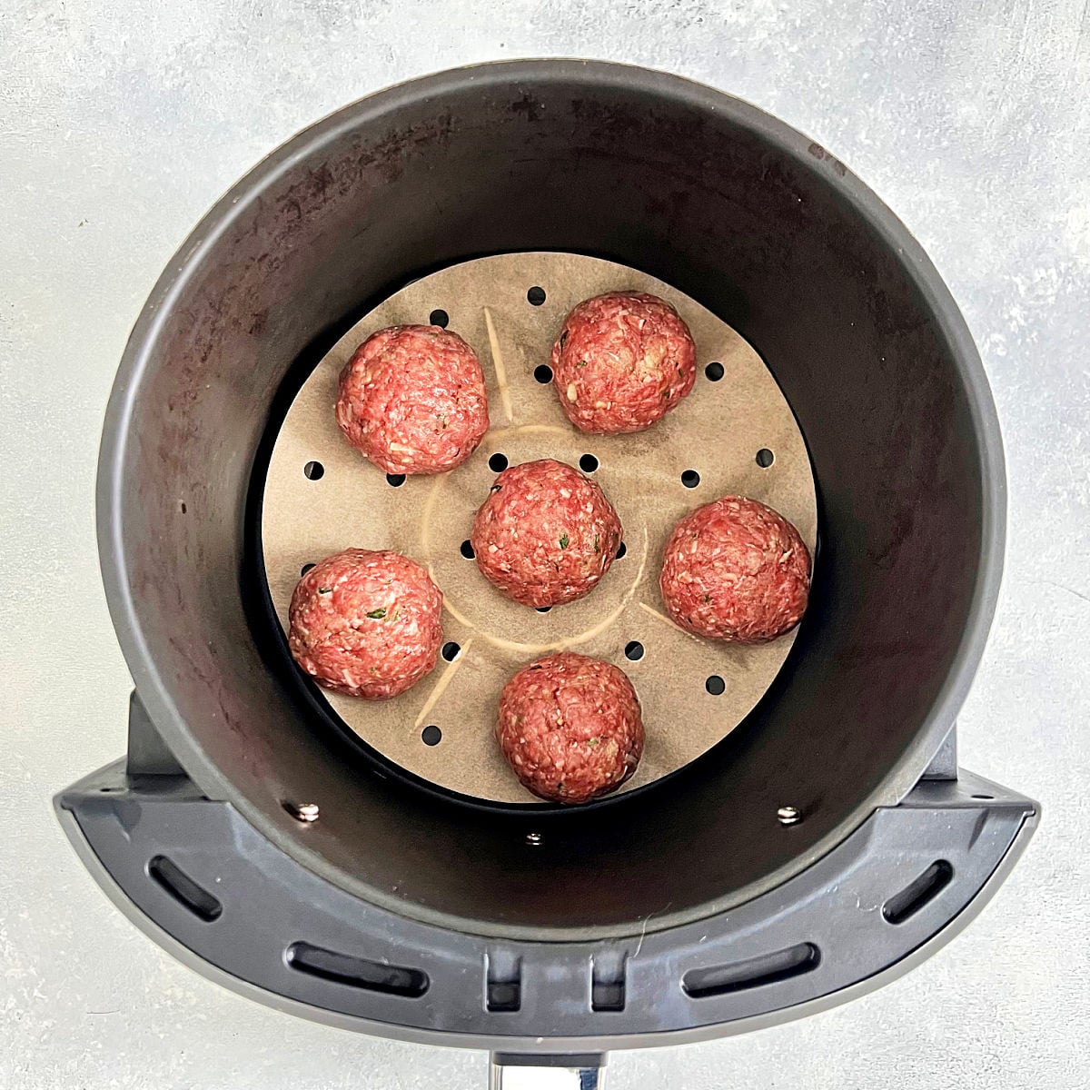 Meatballs on parchment paper in an air fryer
