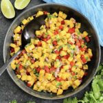 Mango salsa in a black bowl.