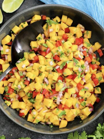 Mango salsa in a black bowl.