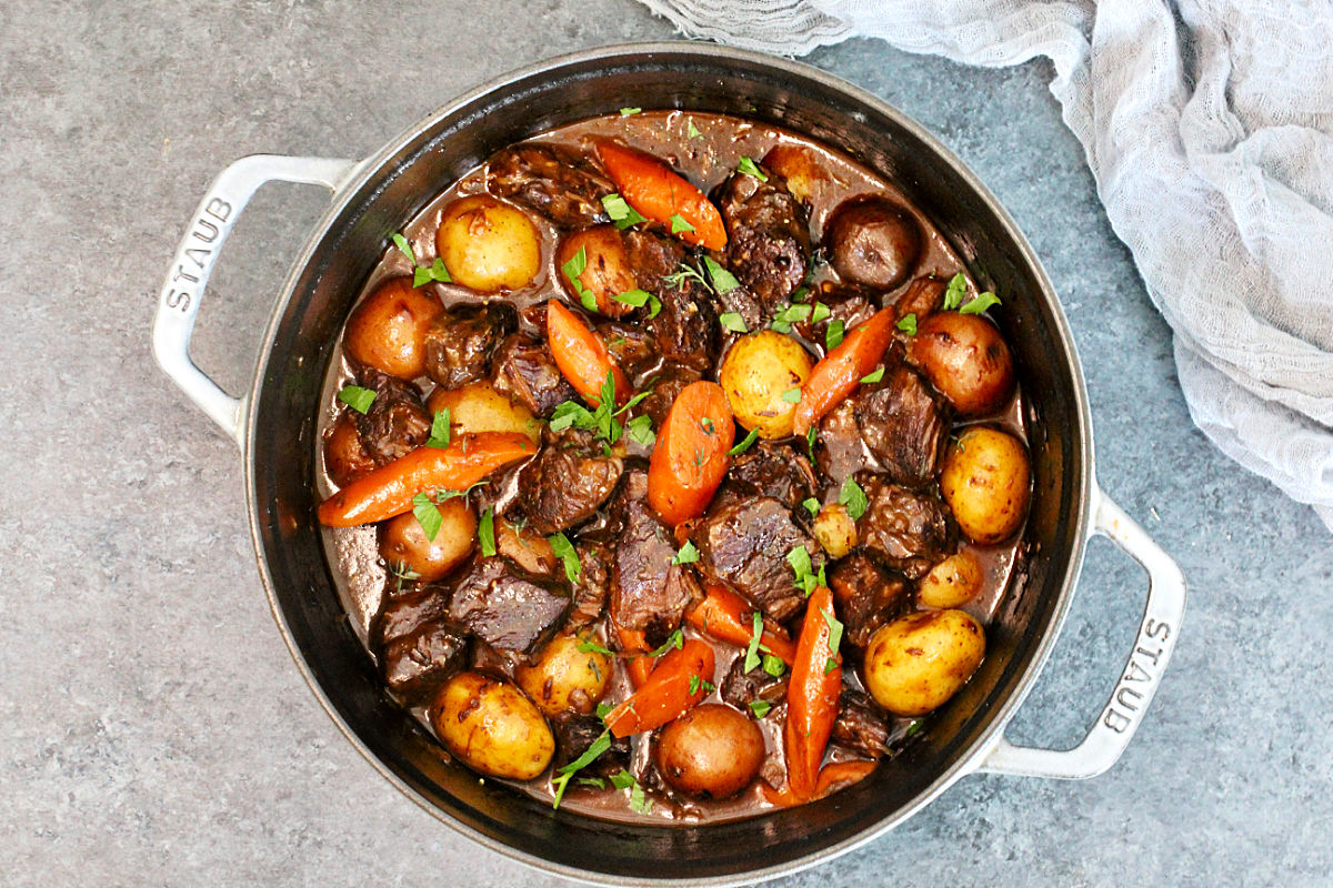 Classic Dutch Oven Beef Stew in a dutch oven on a slate board.