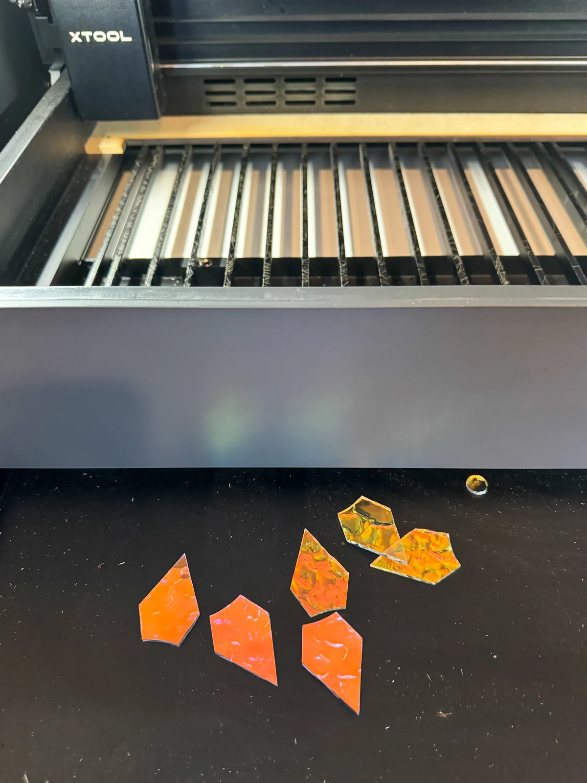 scrap pieces of iridescent acrylic in the xTool P2 crumb tray