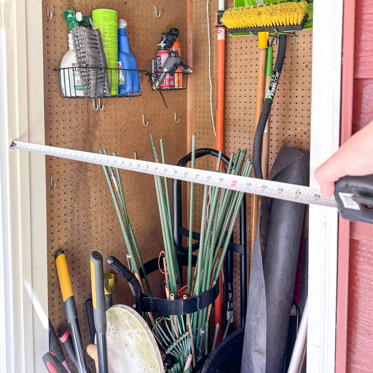 measuring across the width of the shed door opening with a tape measure