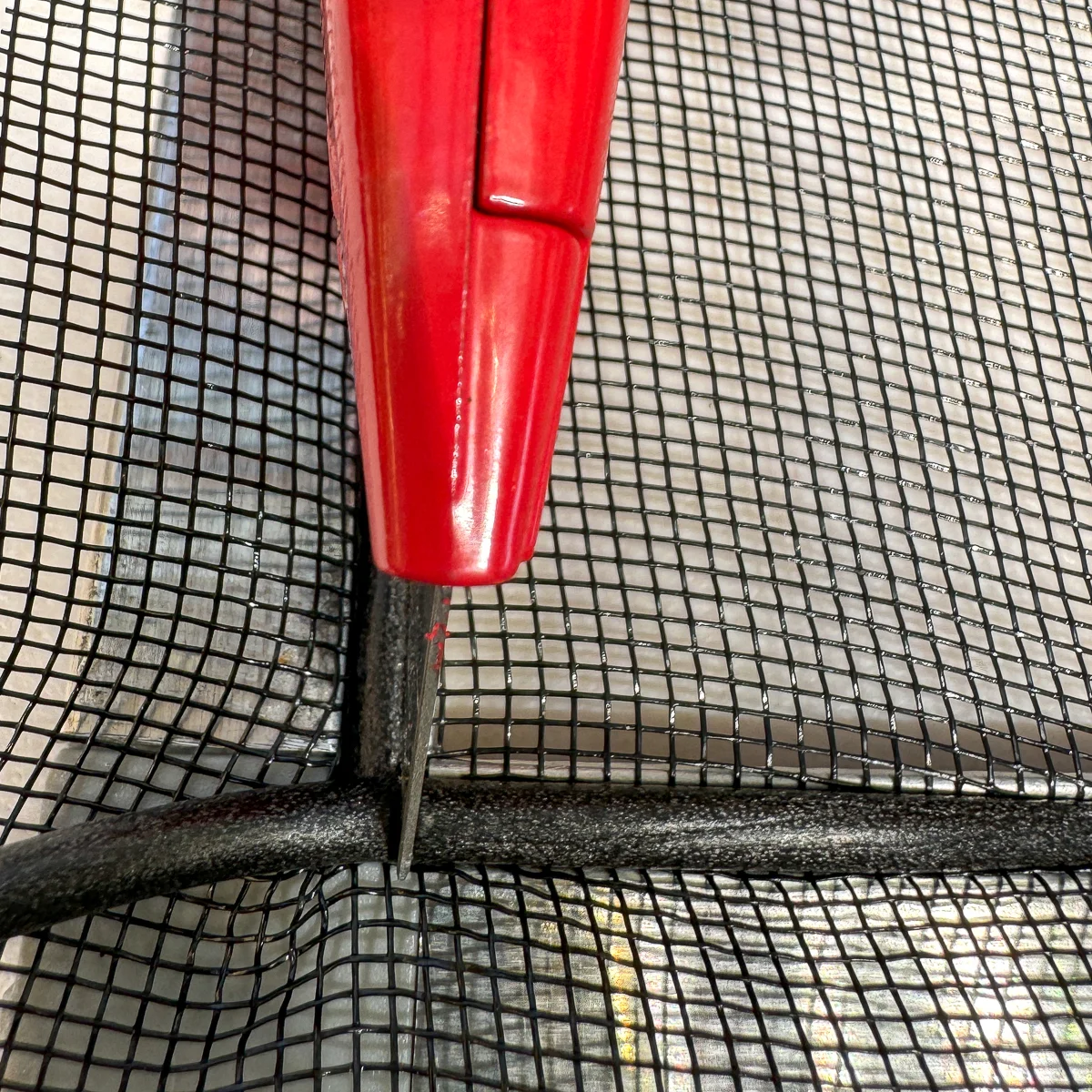 using a utility knife to mark the cut on the rubber spline