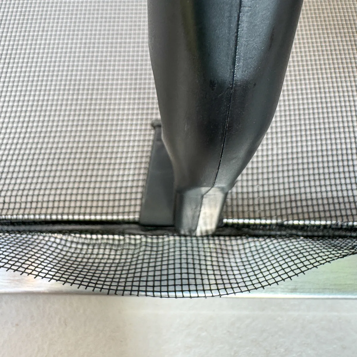 pressing the spline into the groove with the pull tab installed
